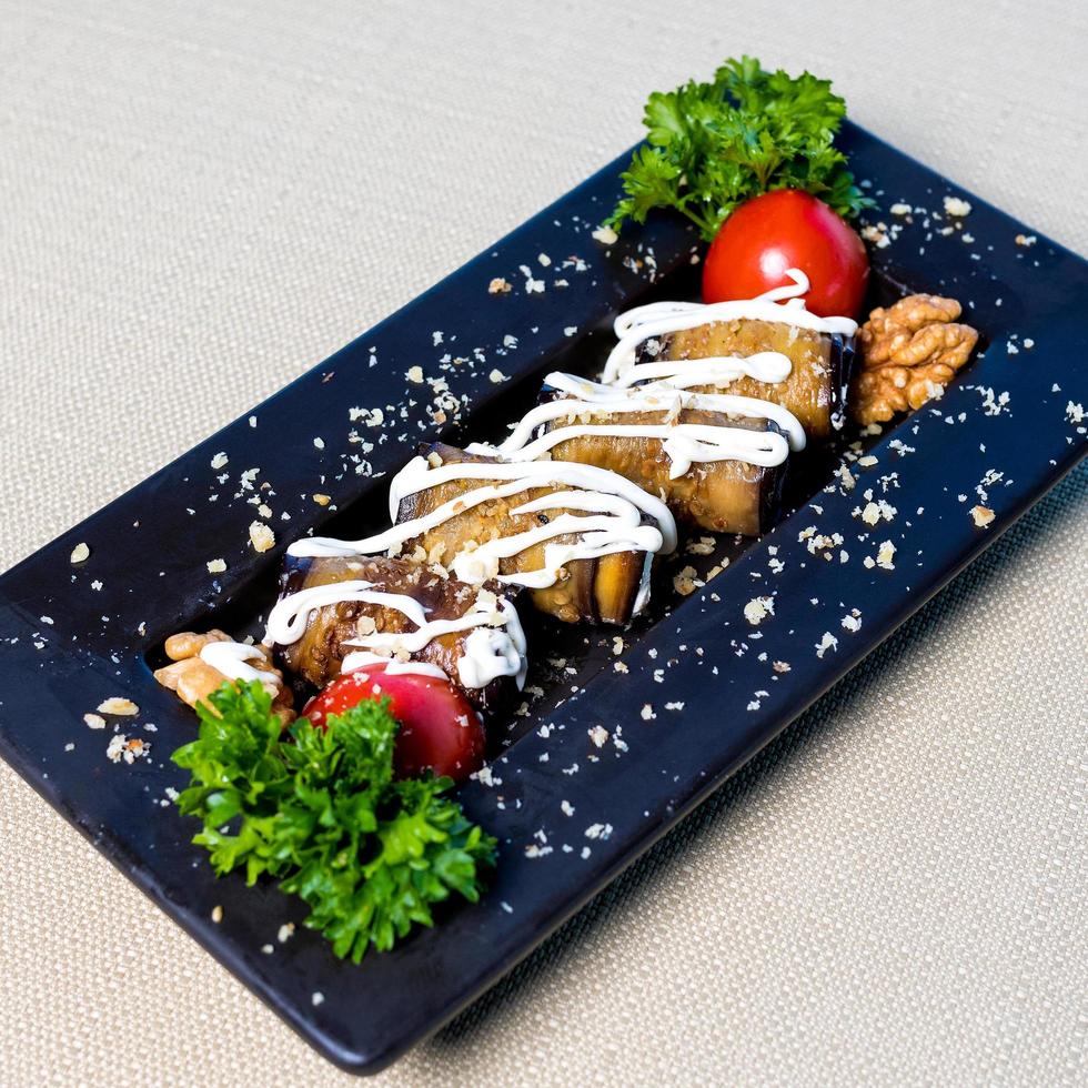 Eggplant, tomato garnish with sauce close up photo