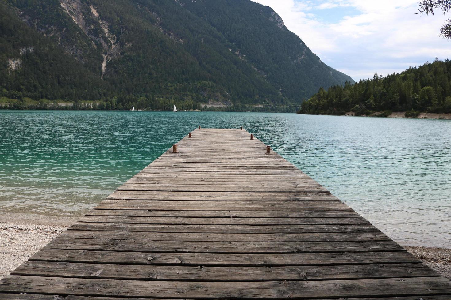 Muelle de madera que conduce a un lago durante el día. foto