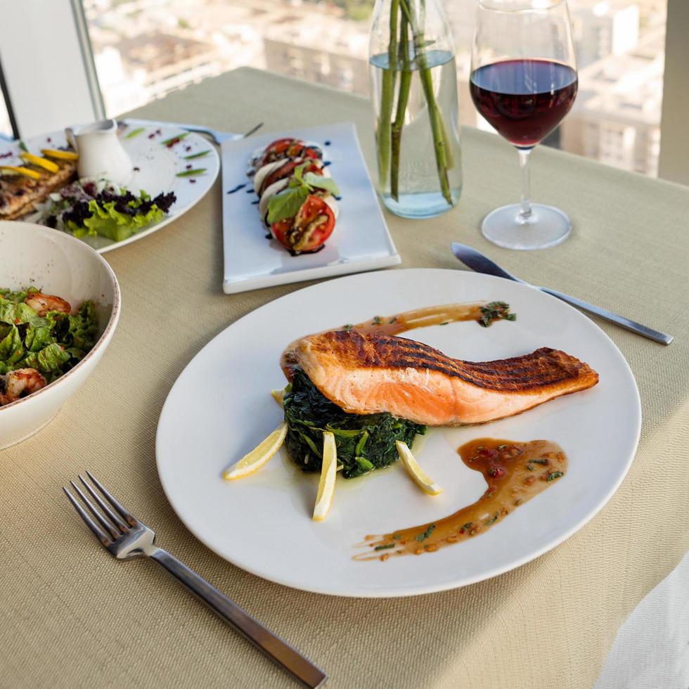 hermosa comida de salmón con limón y vino tinto foto