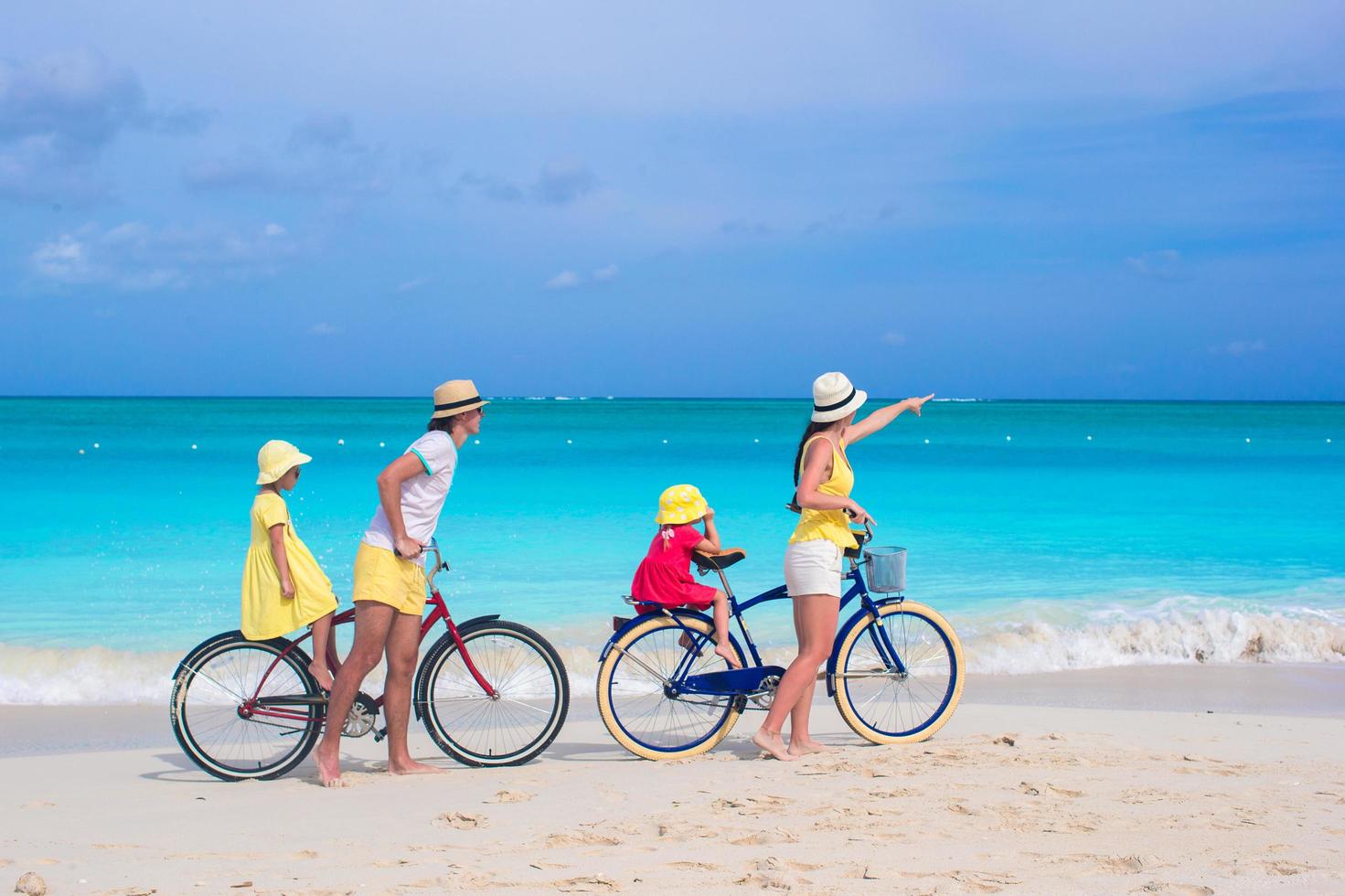 Family riding bikes on a beach photo