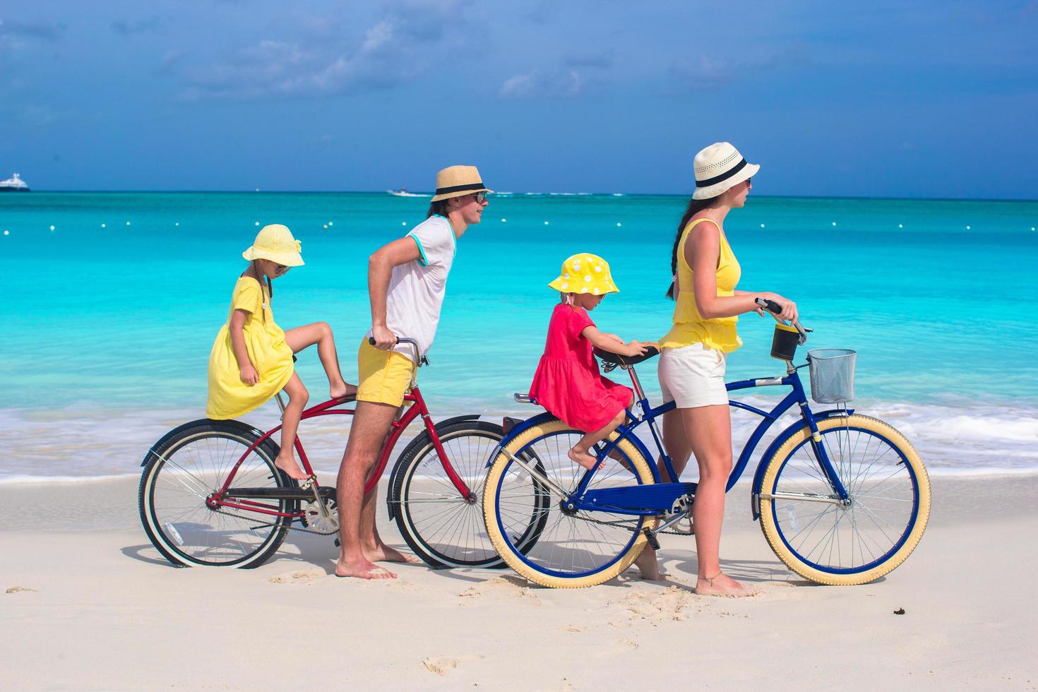 Young parents and kids riding bicycles on a beach photo