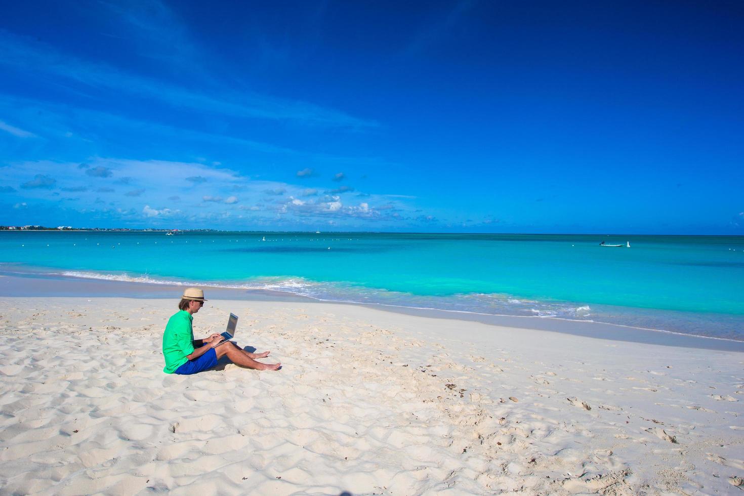 Man using a laptop the beach photo