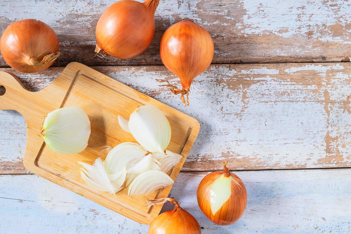 Cebolla cortada sobre una tabla de cortar de madera foto