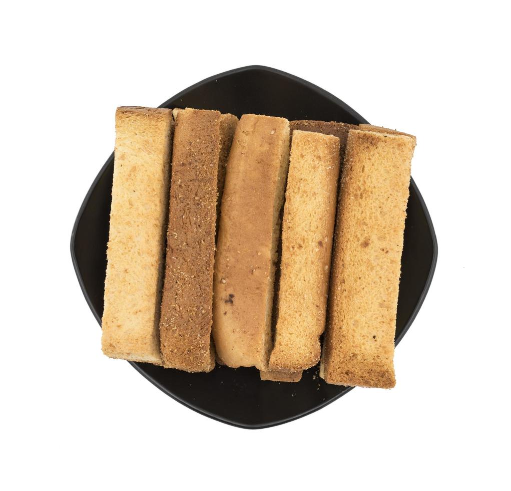 Vista superior de palitos de pan tostado en una placa negra foto