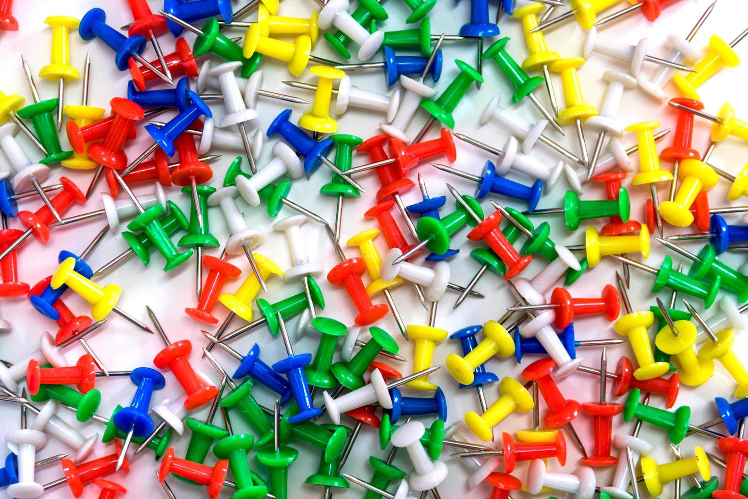 Colorful thumbtacks on white background photo