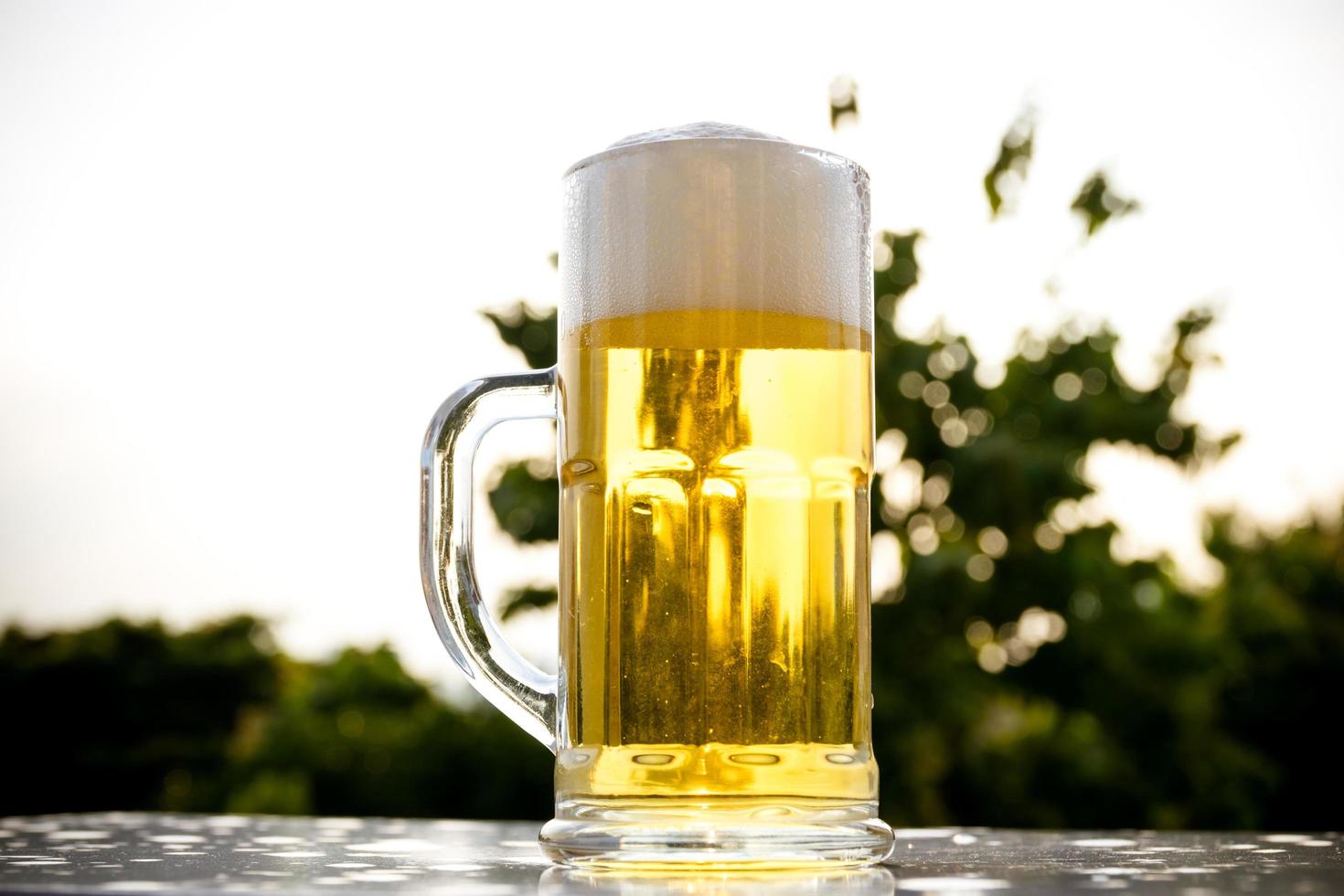 A pint of beer on natural tree line background photo