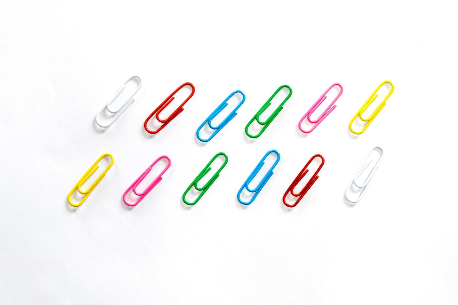 Colorful paperclips on white background photo