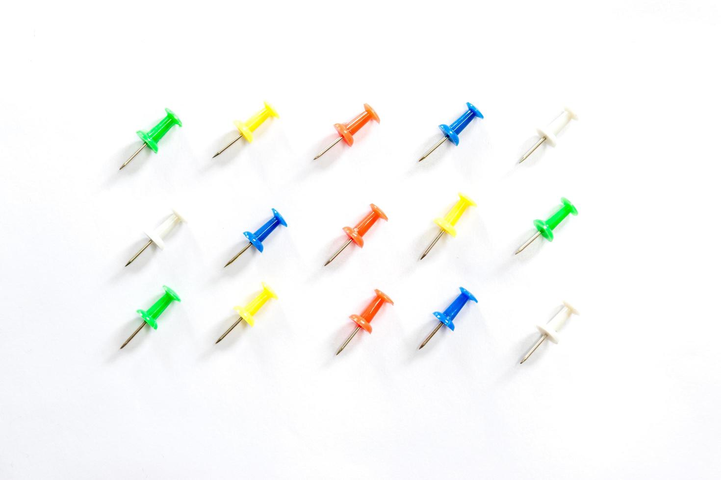 Colorful thumbtacks on white background photo