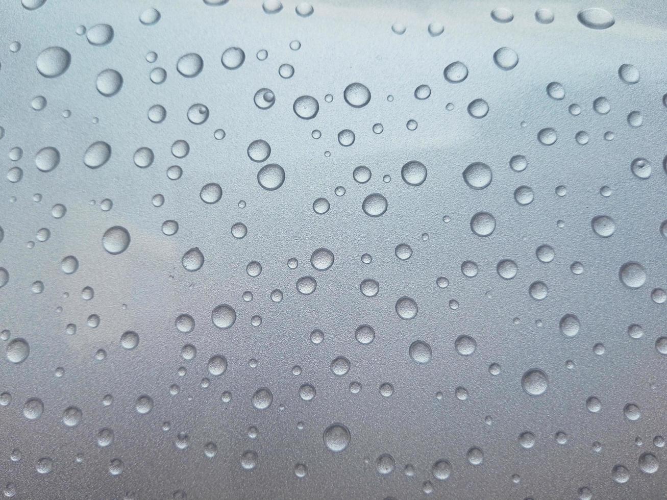 gotas de lluvia sobre una superficie translúcida foto