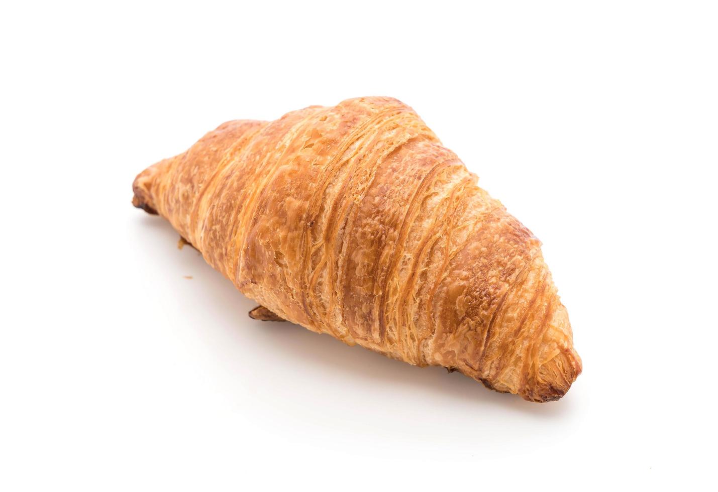 Croissant de mantequilla sobre fondo blanco. foto