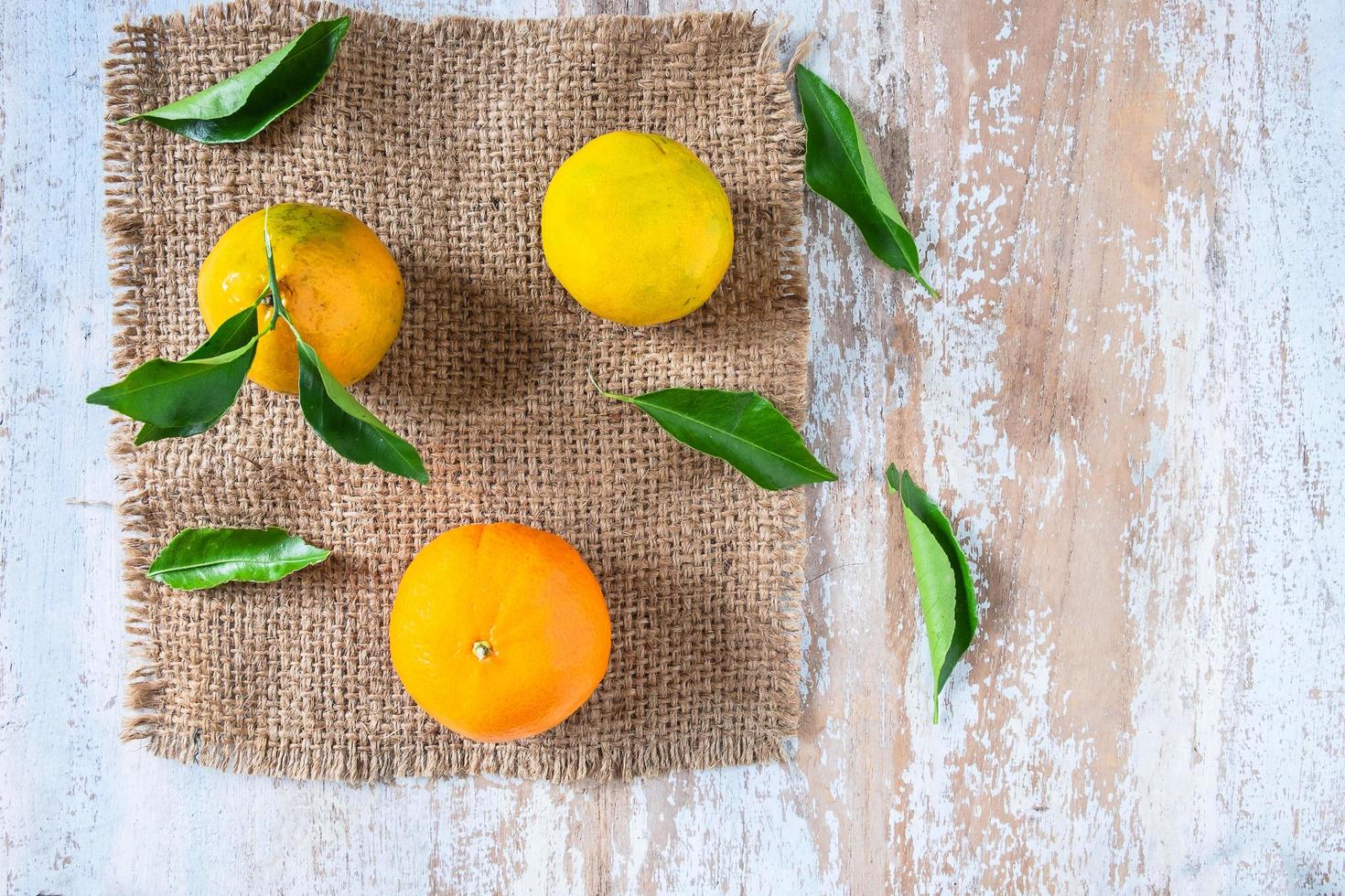 fruta naranja y hojas sobre la mesa foto