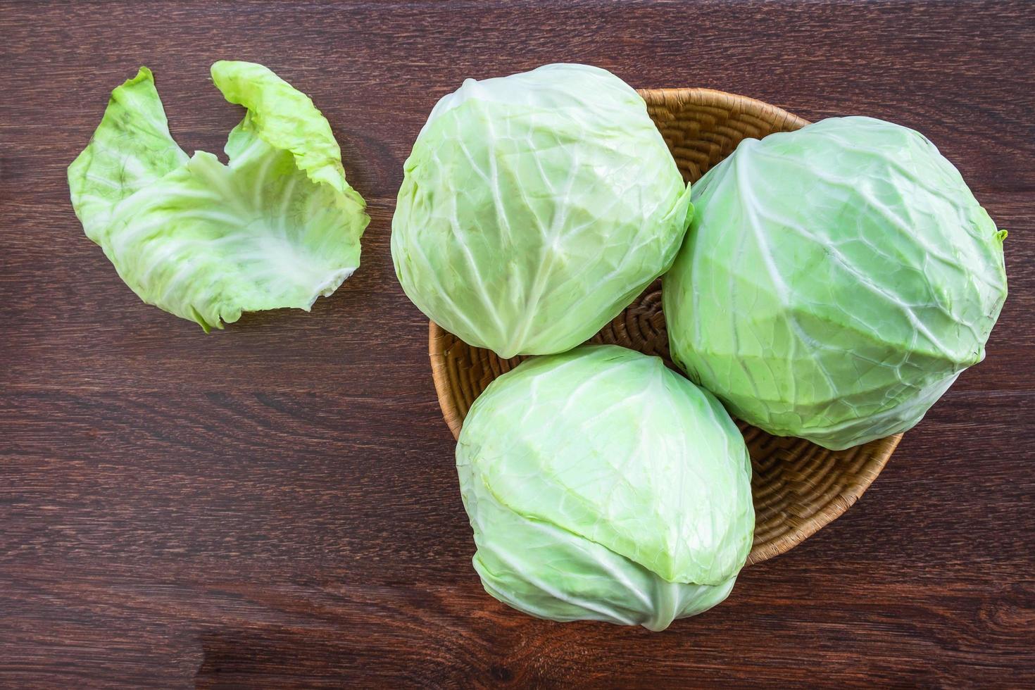 Cabbage in a basket on a wooden table photo