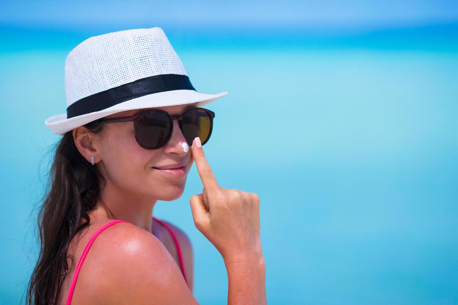 Woman applying sunscreen on her nose photo