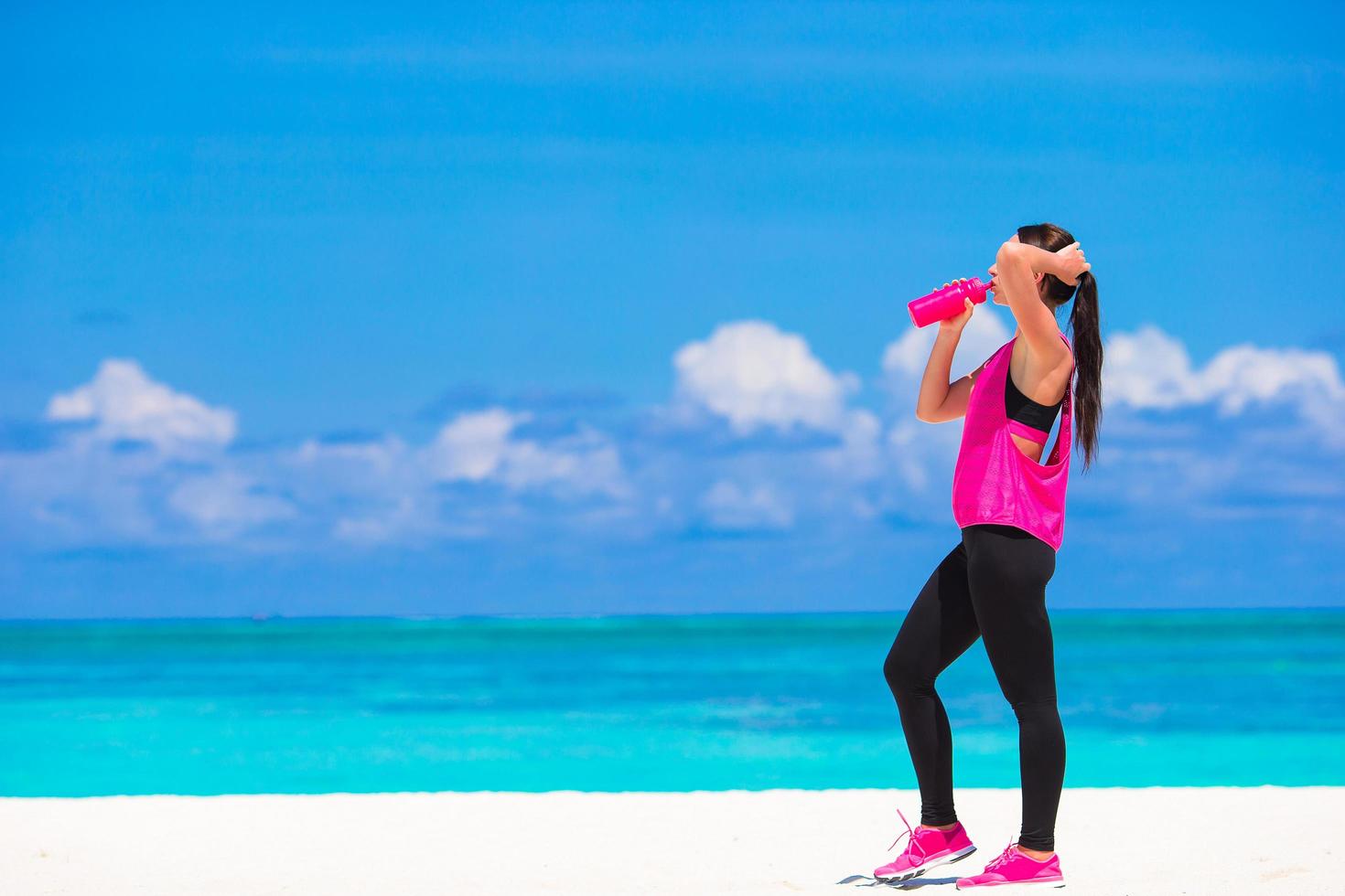 Woman drinking water on an exercise break photo