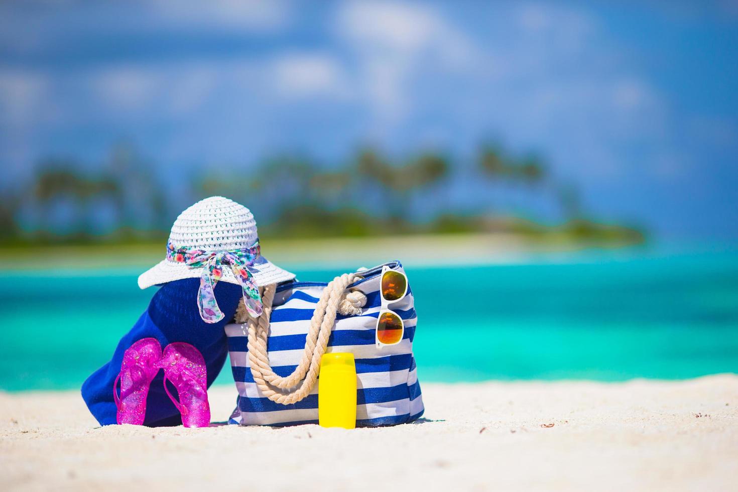 Beach bag and accessories on a beach photo