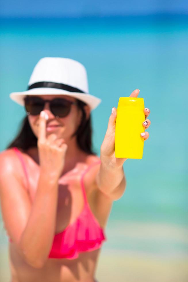 mujer aplicando protector solar durante el día foto