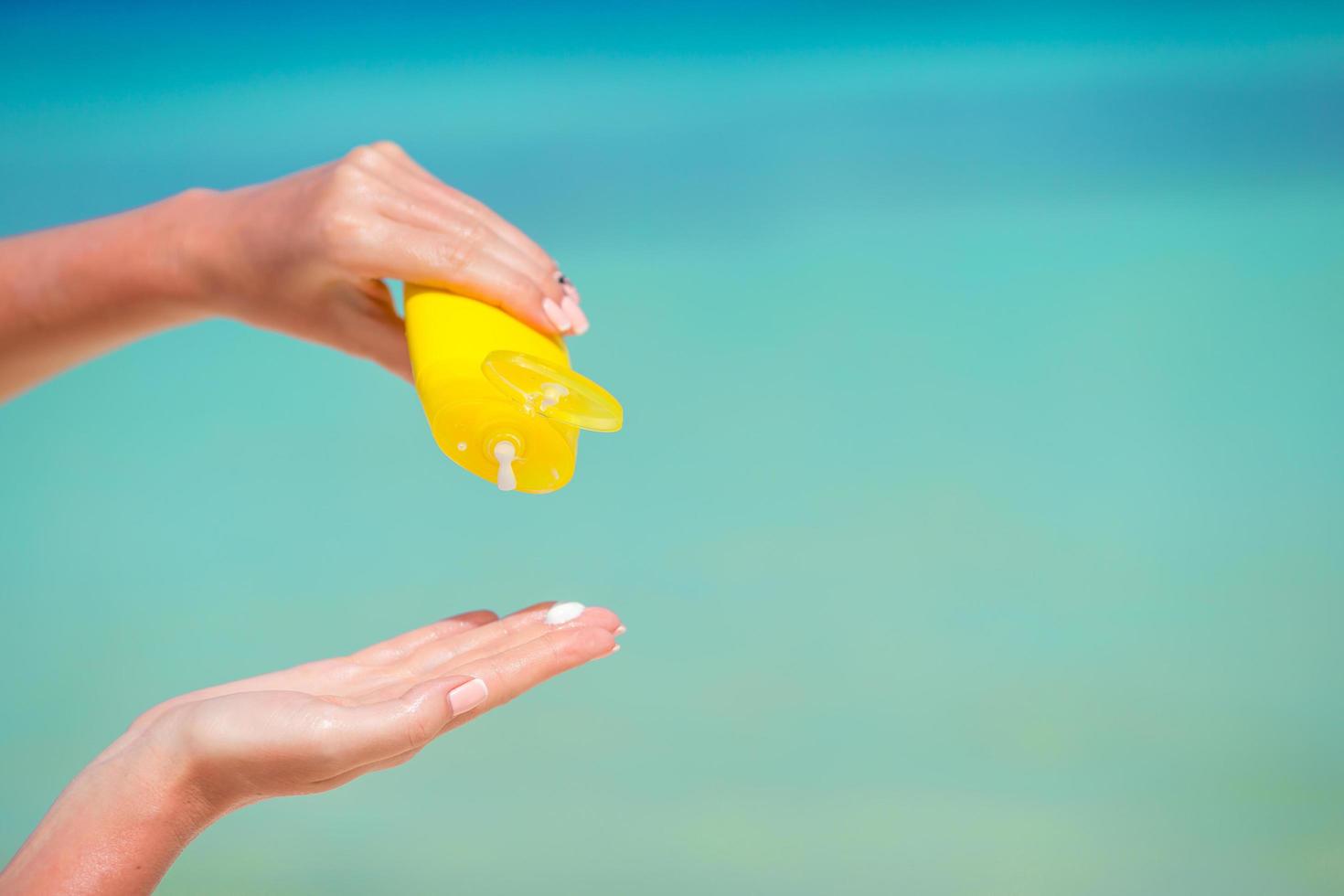 Close-up of hands applying sunscreen photo