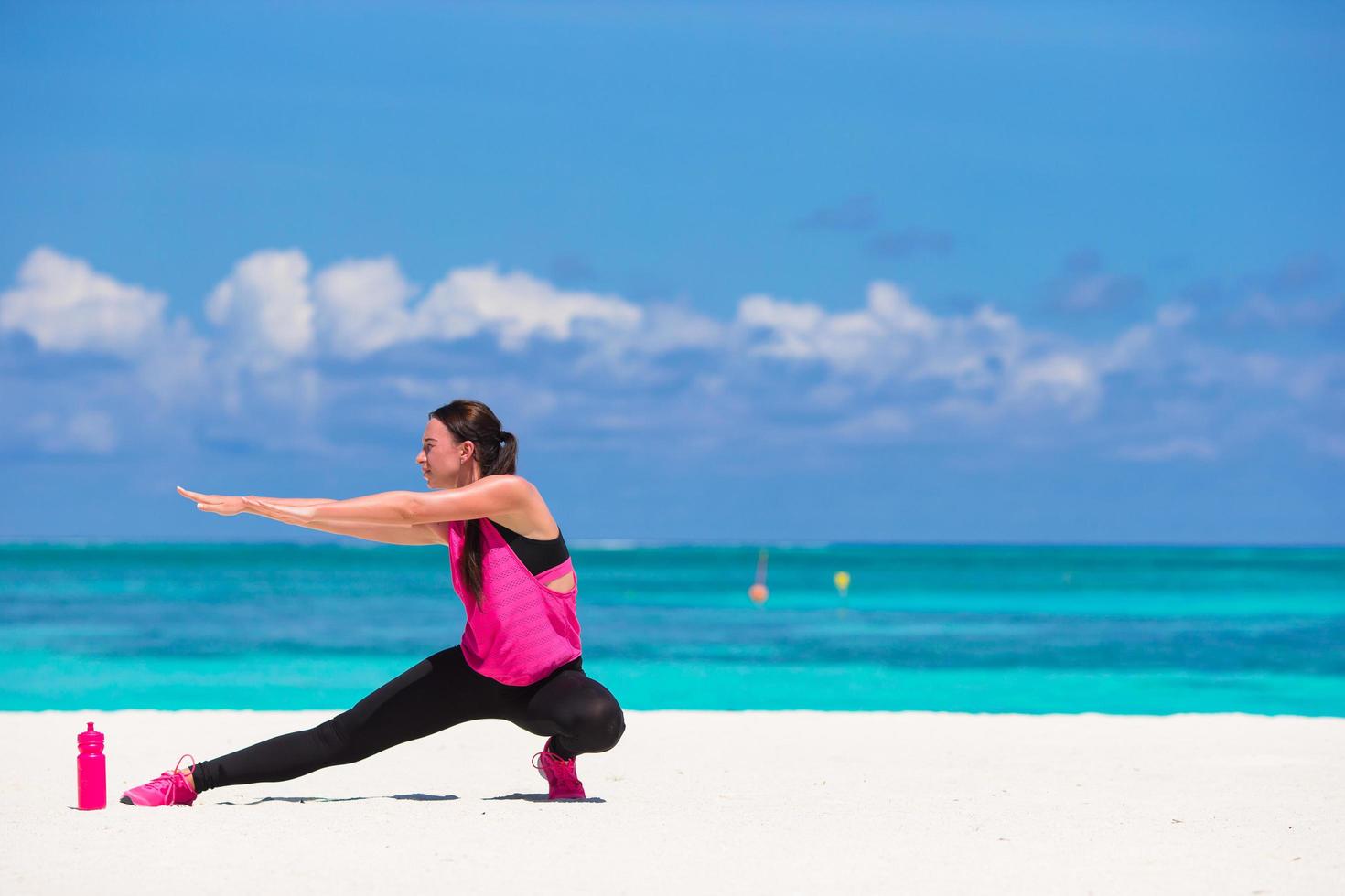 Mujer haciendo ejercicios en una playa blanca foto