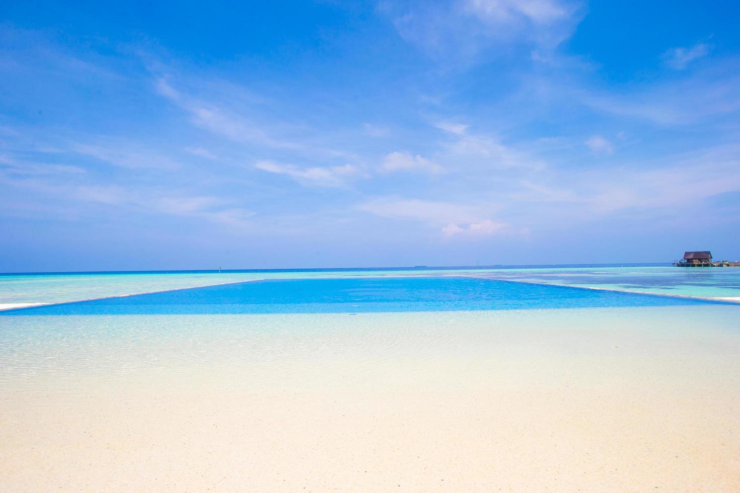 Infinity swimming pool at a tropical beach photo