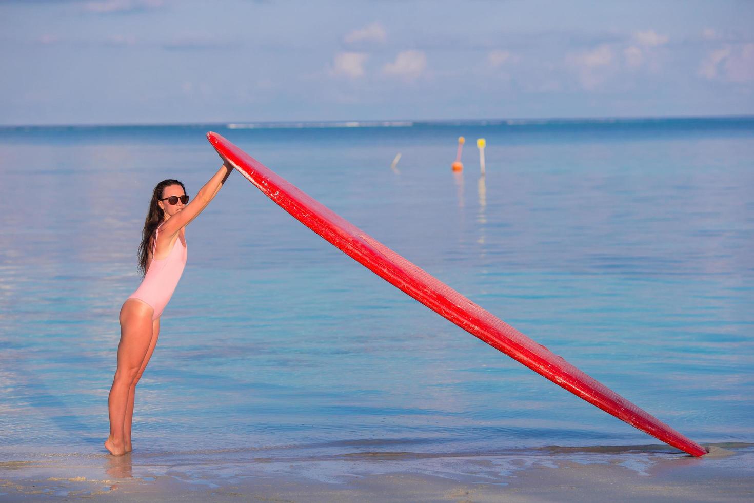 mujer sosteniendo una tabla de surf foto