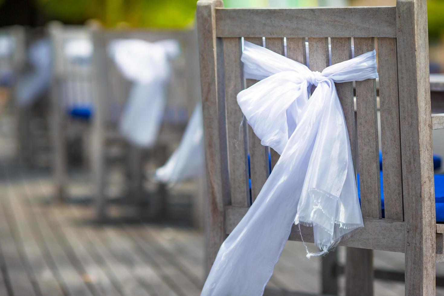 Wooden chairs with white bows photo