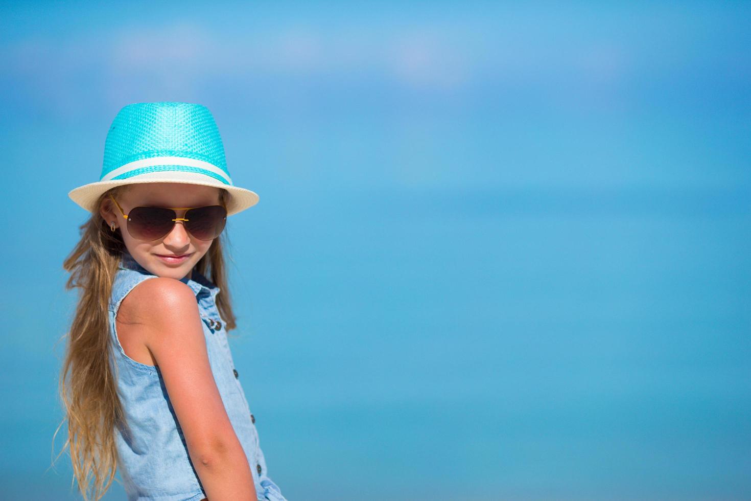 chica con sombrero y gafas de sol en la playa foto