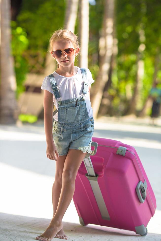 chica con una maleta rosa foto