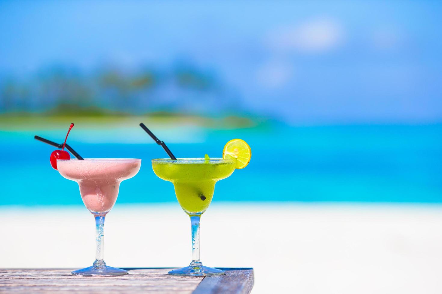 Two mixed drinks at a beach photo