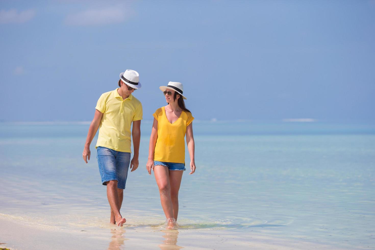 pareja caminando en el agua en la playa foto