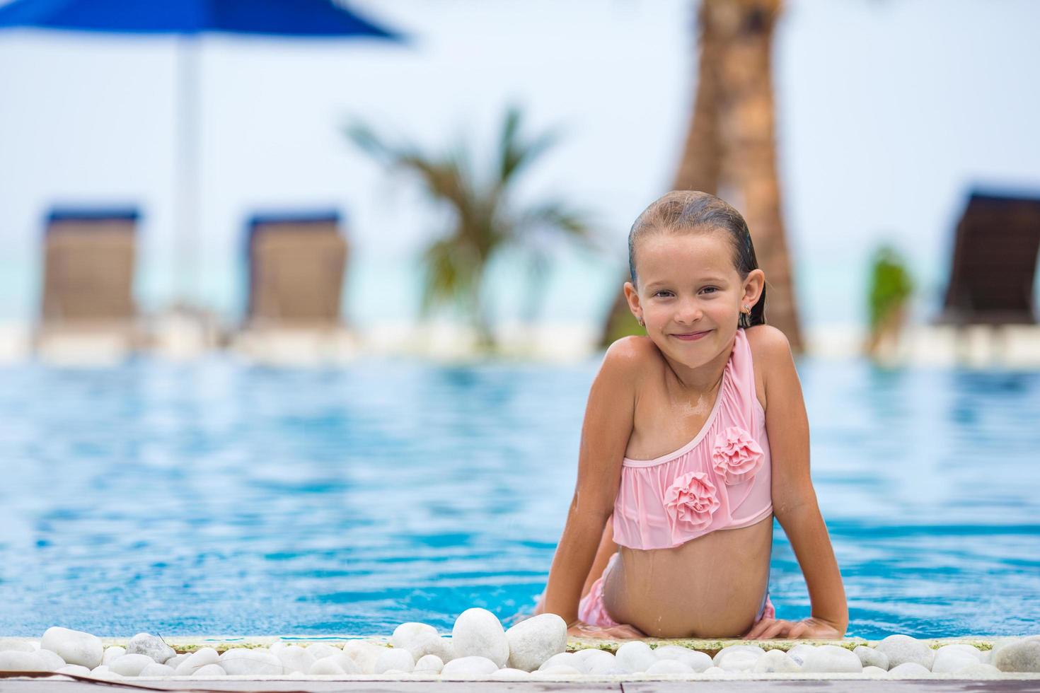 Girl having fun in an outdoor swimming pool photo