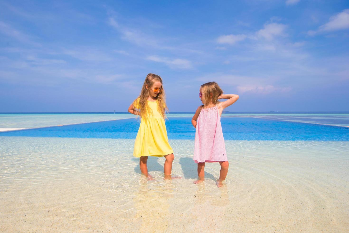 Two sisters having fun near a swimming pool photo