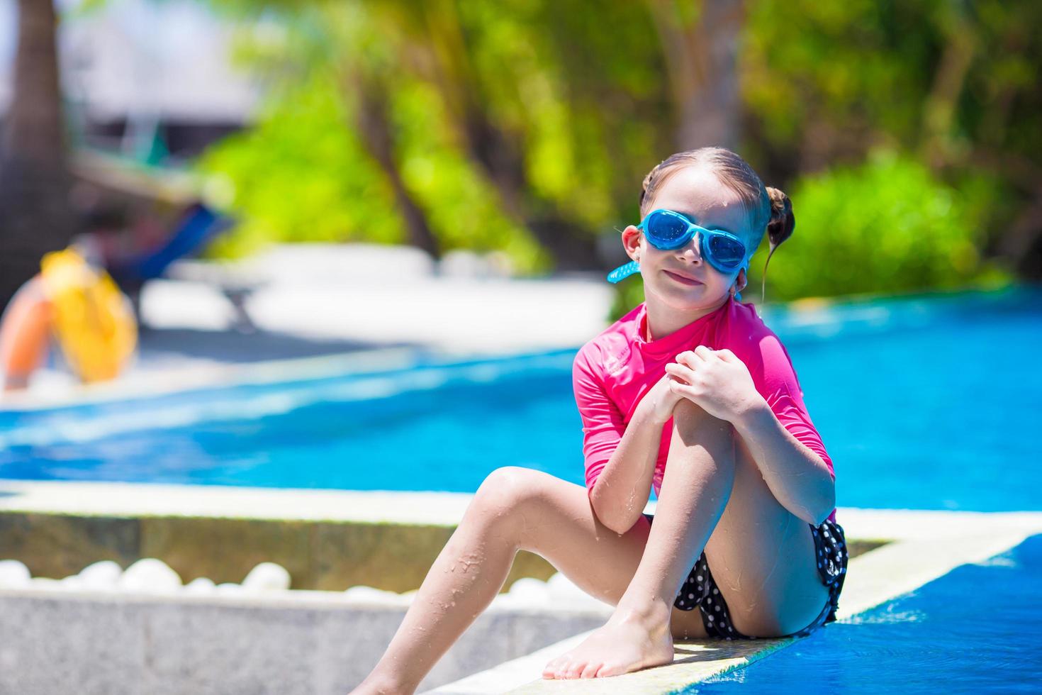 niña sentada al lado de una piscina 1739057 Foto de stock en Vecteezy