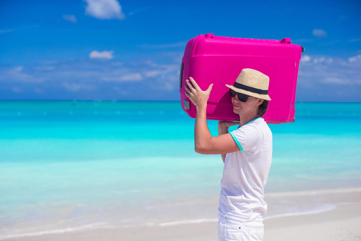 hombre cargando su equipaje en la playa foto