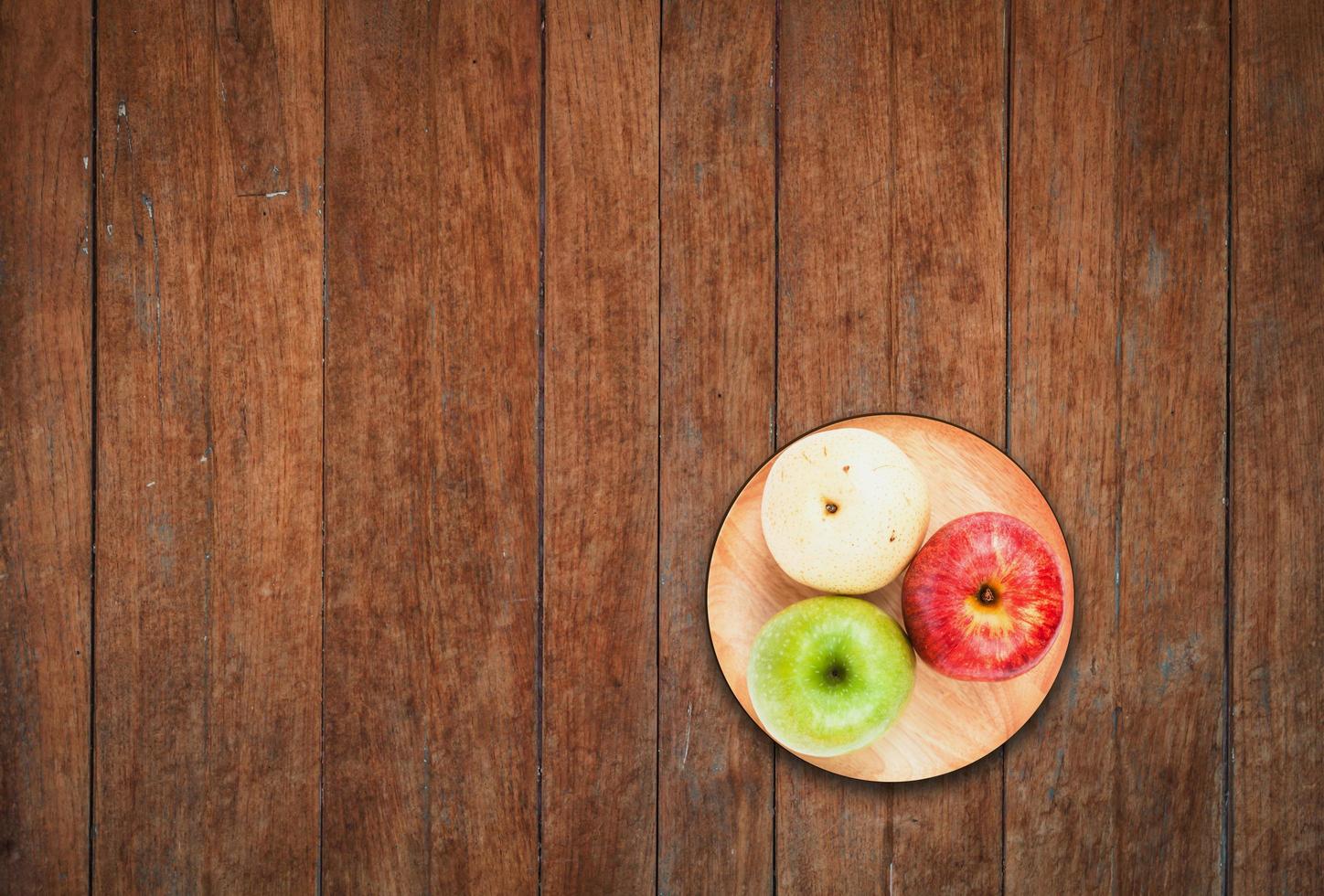 Top view of three apples on a wooden background photo