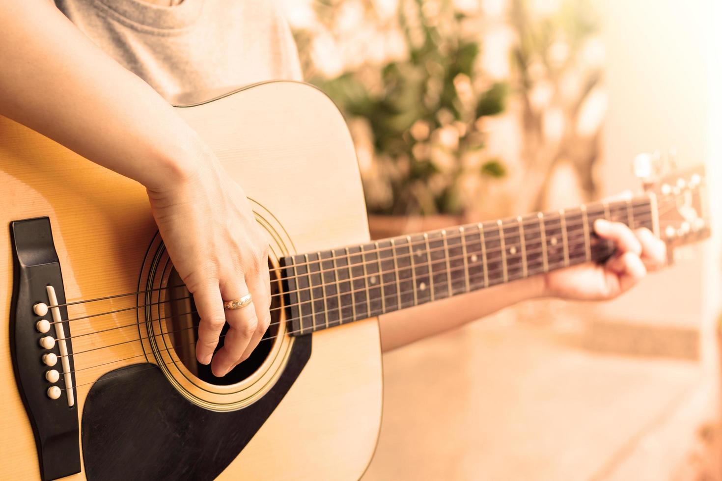Close-up of person playing an acoustic guitar photo