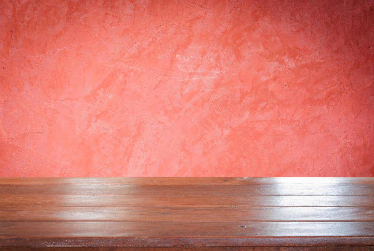 mesa de madera contra una pared roja foto