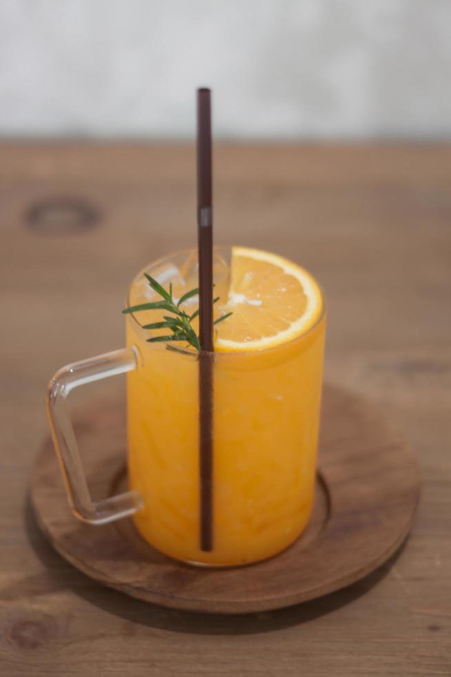 vaso de jugo de naranja con una pajita foto