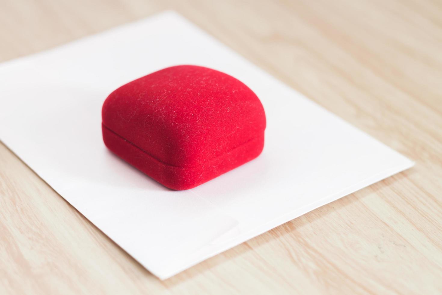 caja de anillo rojo sobre una mesa foto