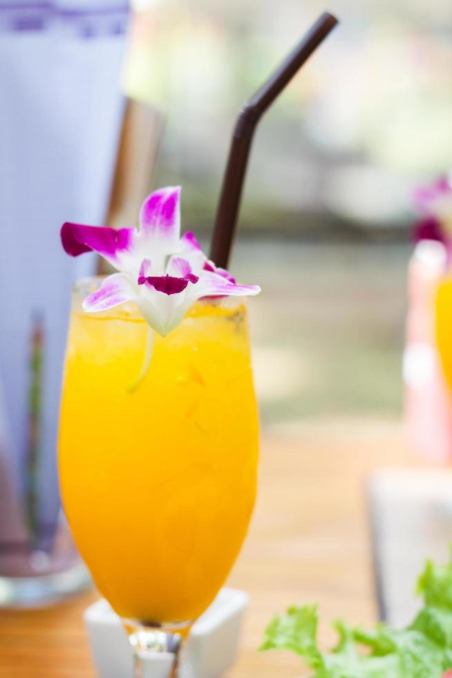 Glass of iced orange juice with a flower photo