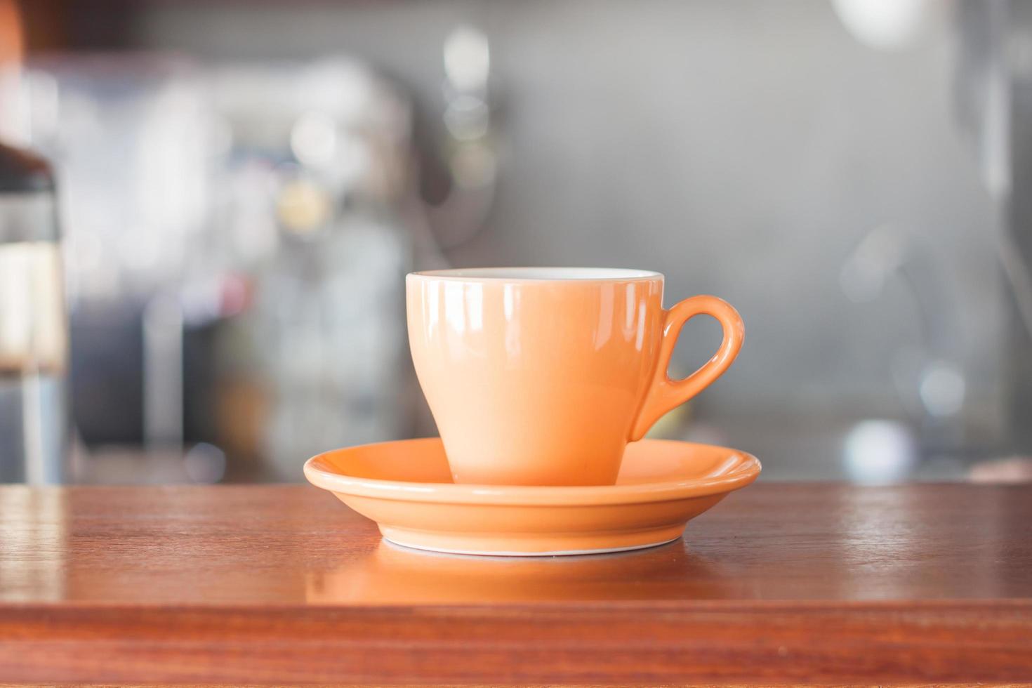 taza de café naranja en un café foto