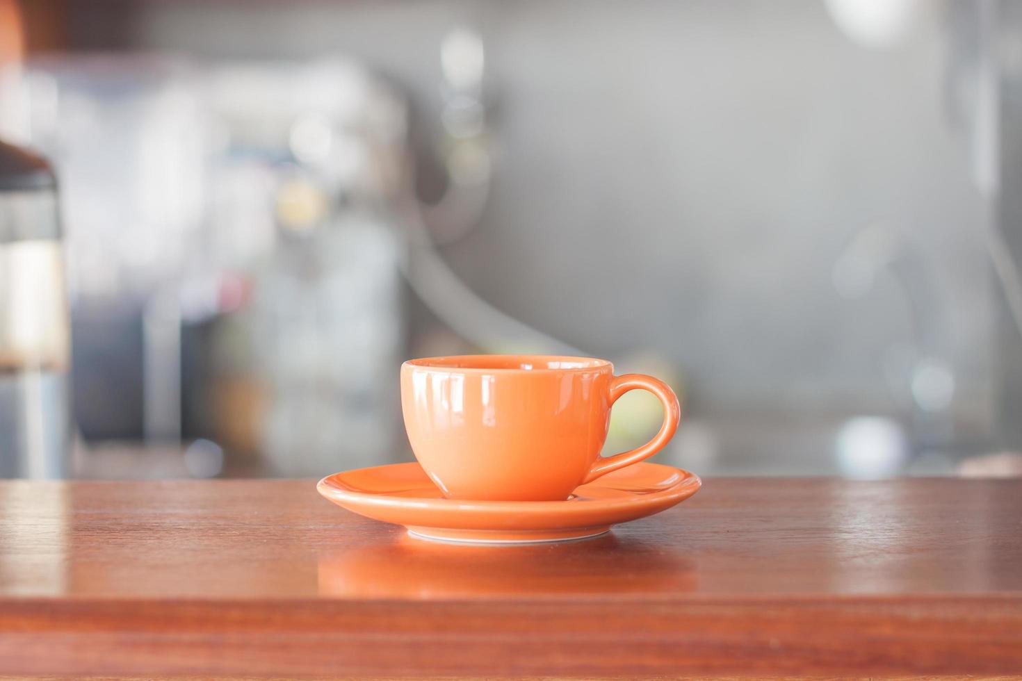 Taza de café naranja en la cafetería. foto