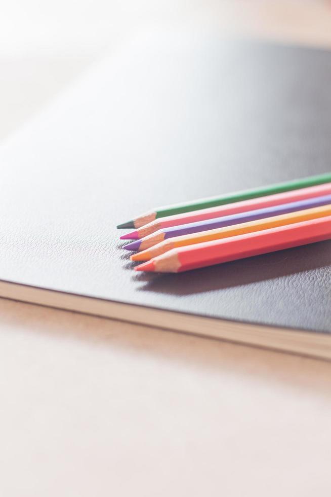 lápices de colores en un cuaderno negro foto
