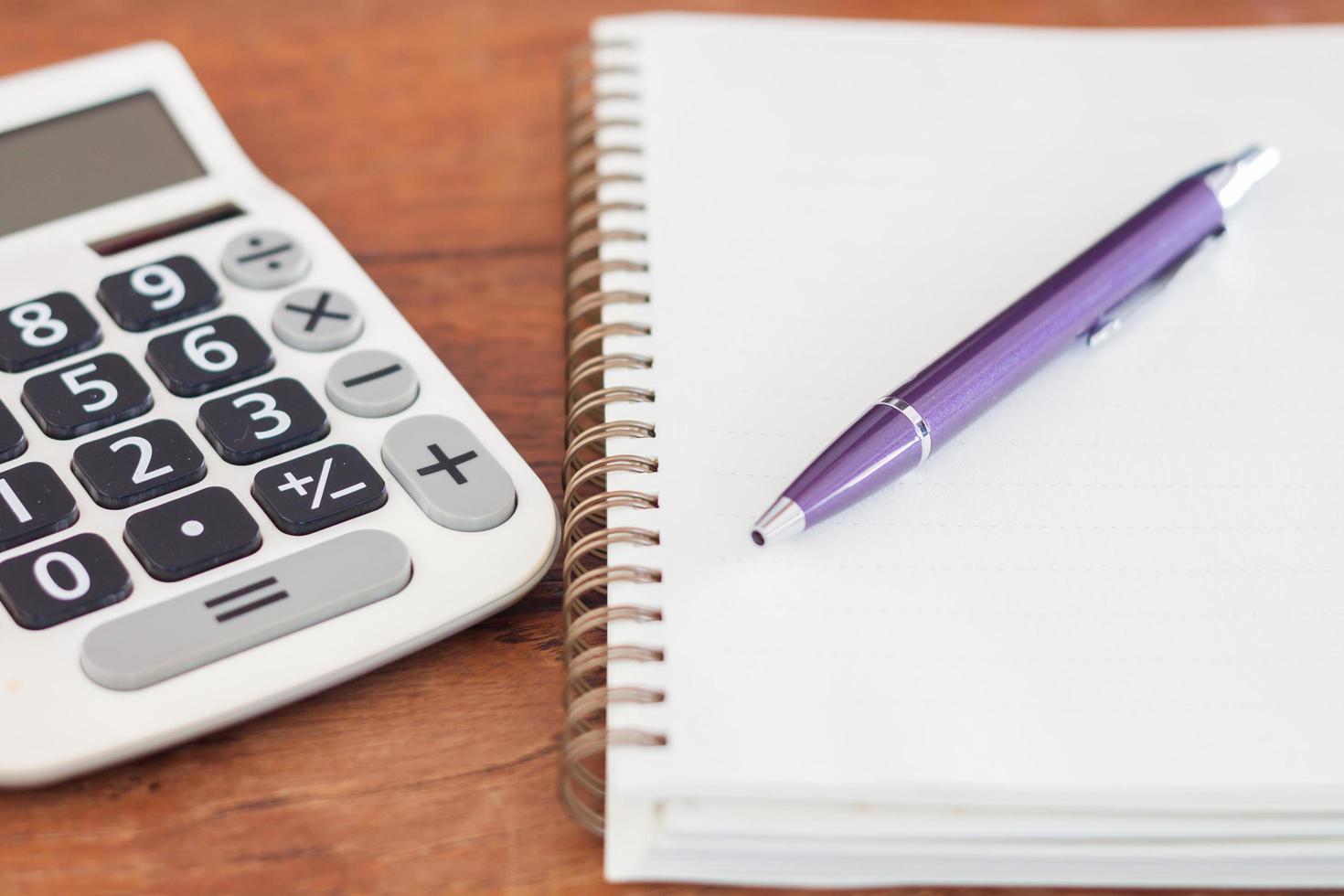 bolígrafo morado y cuaderno con calculadora foto