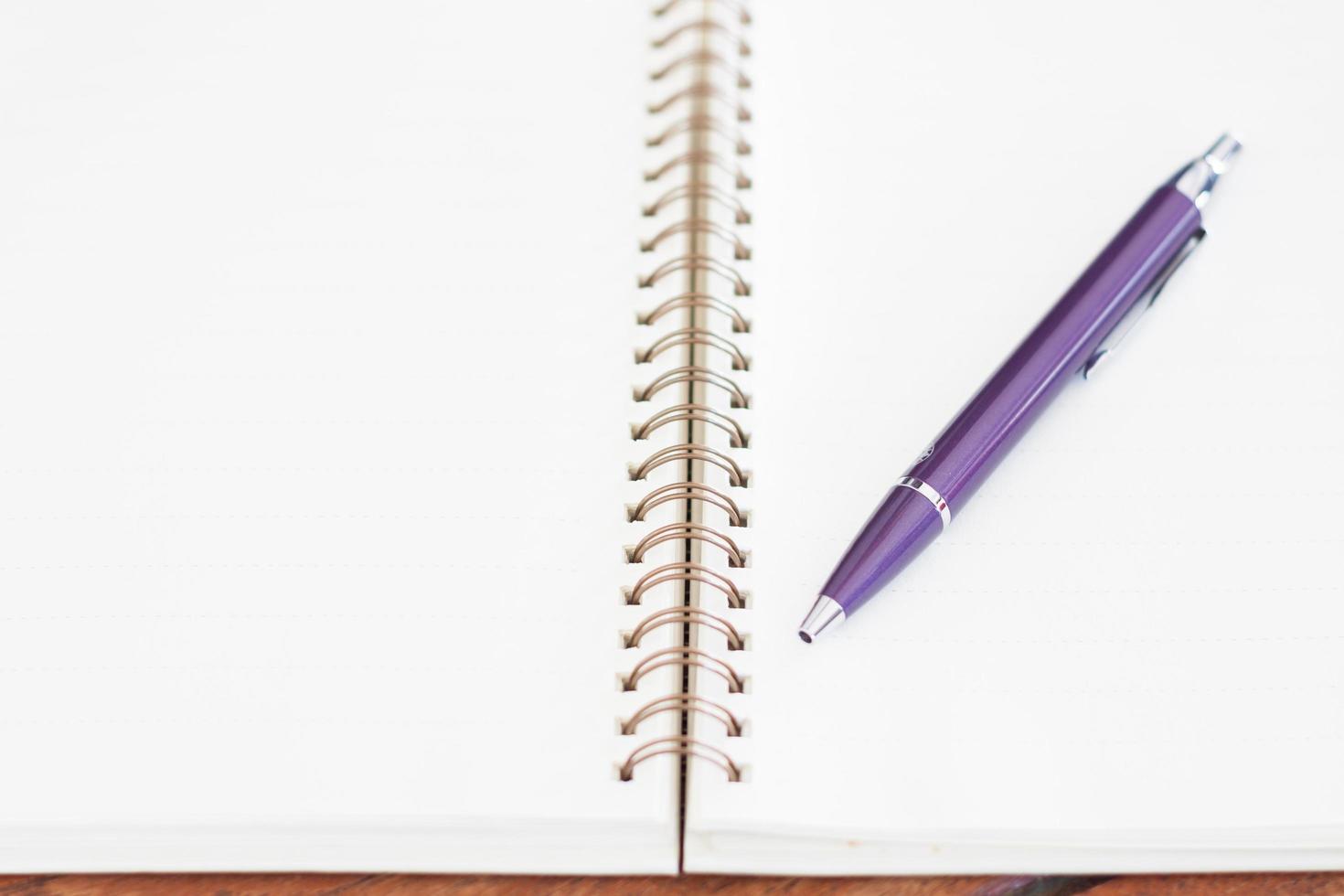 Spiral notebook with a pen on it photo