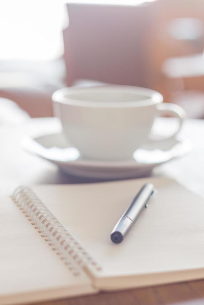 Notebook with a pen and a coffee photo