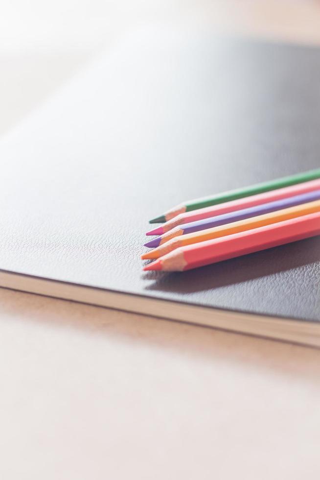 Colorful pencils on black notebook photo