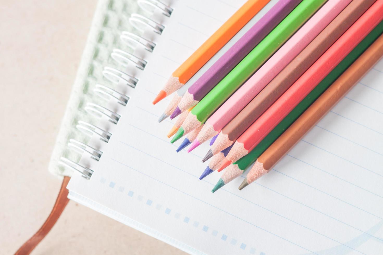 Top view of colorful pencils on a spiral notebook photo