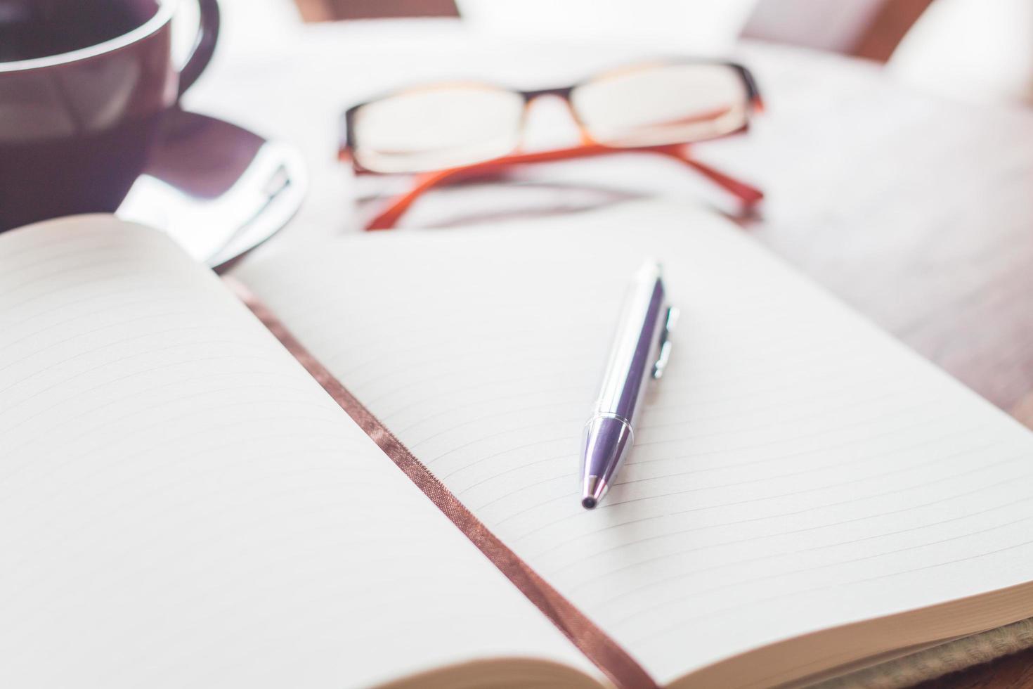 Pen on a notebook with eyeglasses photo