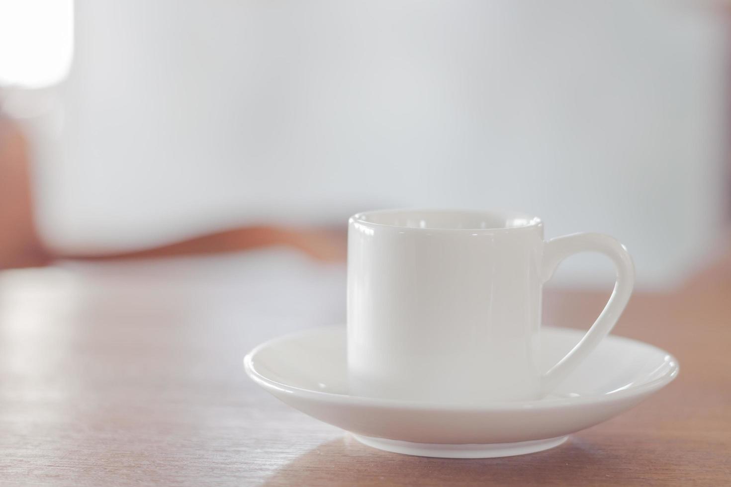 Mini white coffee cup on a wooden table photo