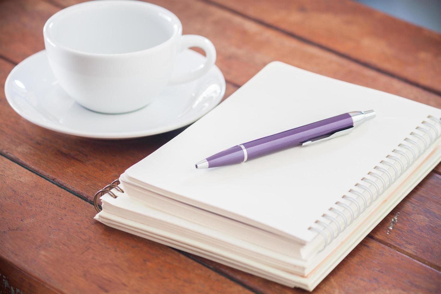 Desk with a coffee and notebook on it photo